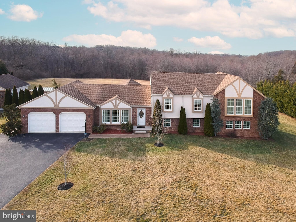 tudor home featuring a garage and a front lawn