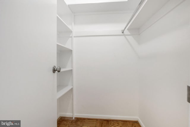 walk in closet with parquet floors