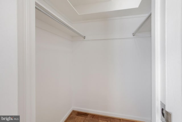 walk in closet with parquet floors