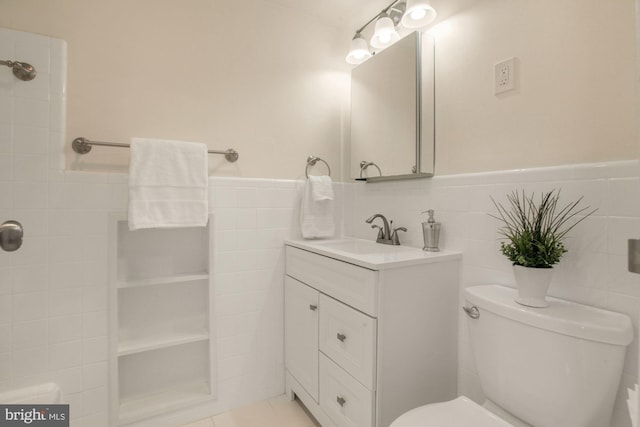 bathroom with tile walls, vanity, tile patterned floors, and toilet