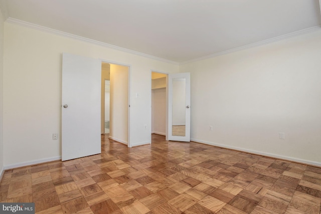 unfurnished bedroom featuring crown molding, a closet, light parquet floors, and a spacious closet