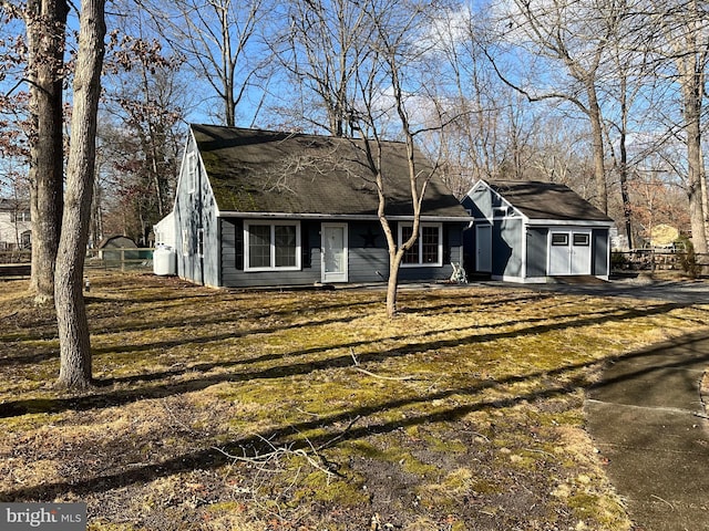 single story home with an outdoor structure and a front lawn