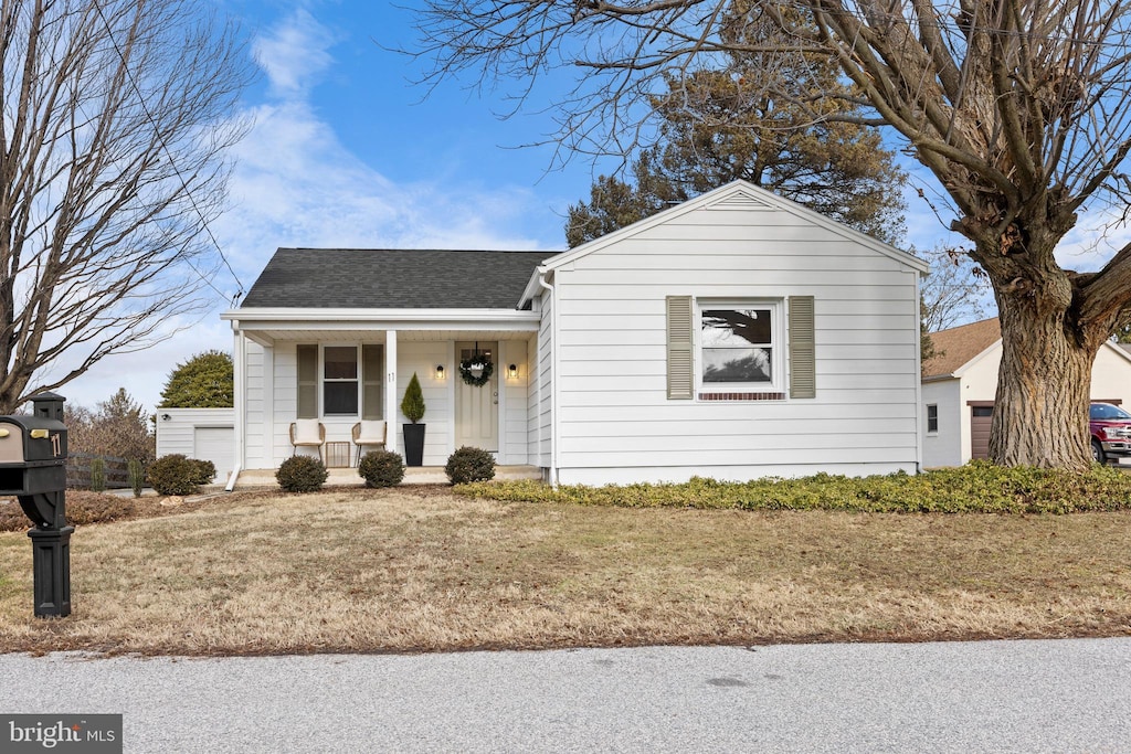 view of front of house featuring covered porch and a front lawn