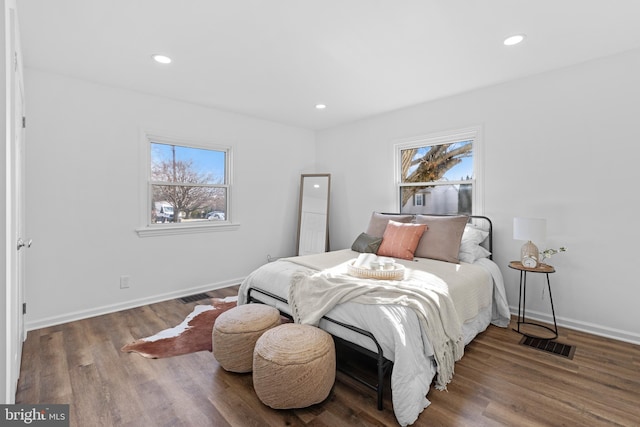 bedroom with multiple windows and hardwood / wood-style flooring