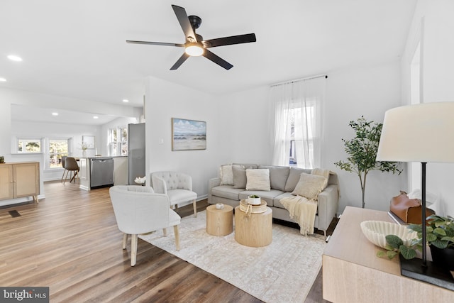 living room with a wealth of natural light, light hardwood / wood-style floors, and ceiling fan