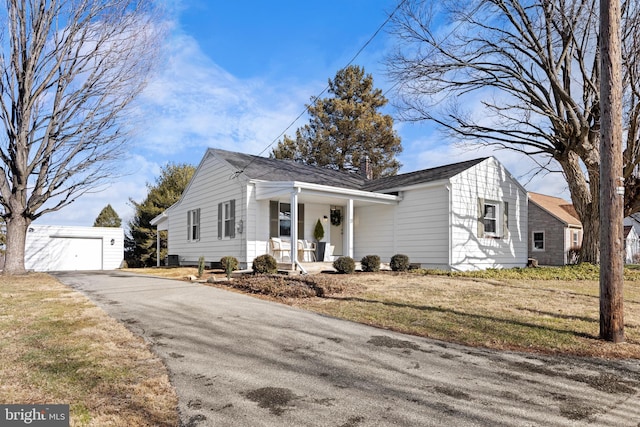 view of front of home with an outbuilding, a garage, a front yard, and covered porch