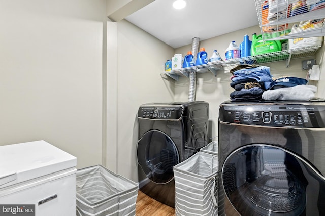 washroom with hardwood / wood-style flooring and washer and dryer