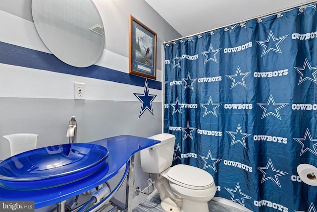 bathroom with a shower with shower curtain and toilet