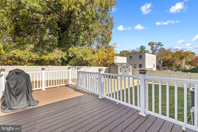 wooden deck featuring a storage shed and a yard