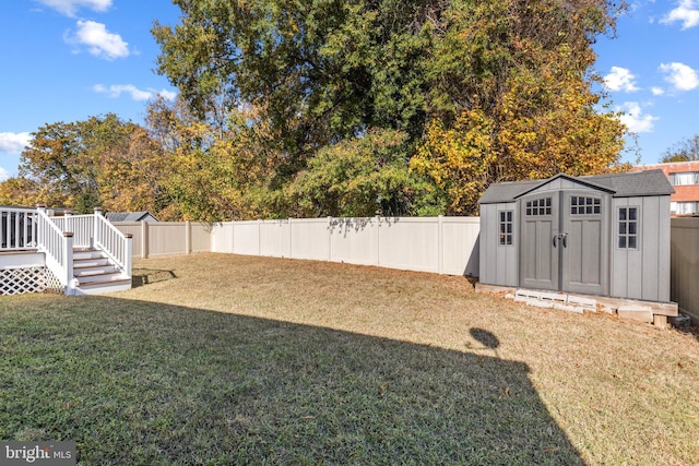 view of yard featuring a wooden deck and a storage unit