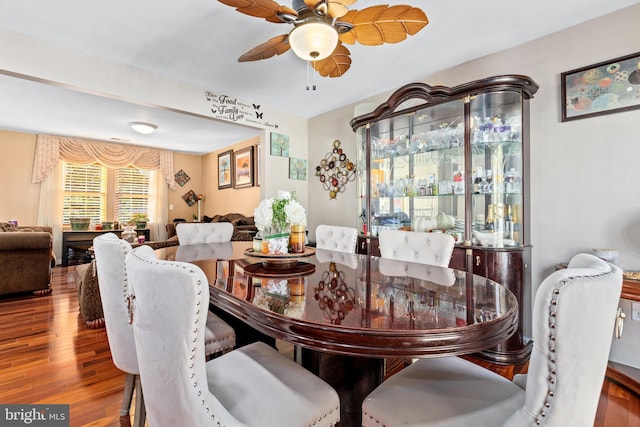 dining area with wood-type flooring and ceiling fan