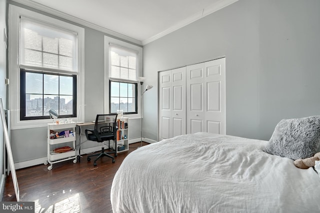 bedroom with ornamental molding, dark hardwood / wood-style flooring, and a closet