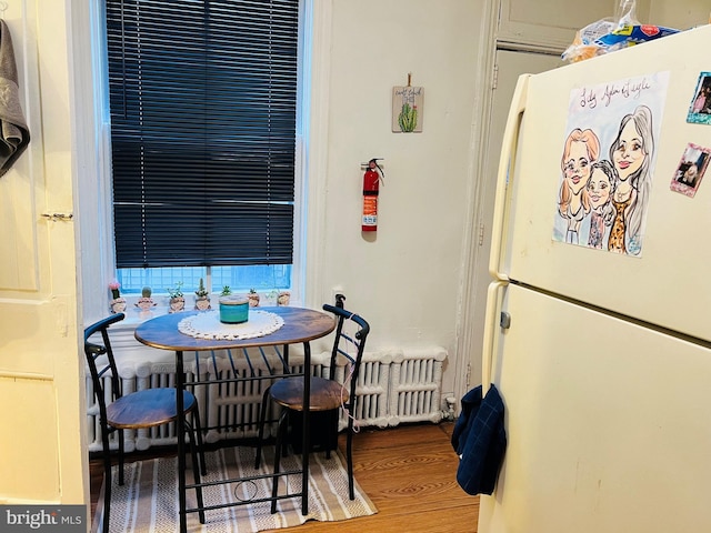 dining area with radiator and wood-type flooring