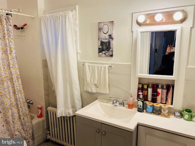 bathroom with vanity, radiator, tile walls, and shower / bath combo