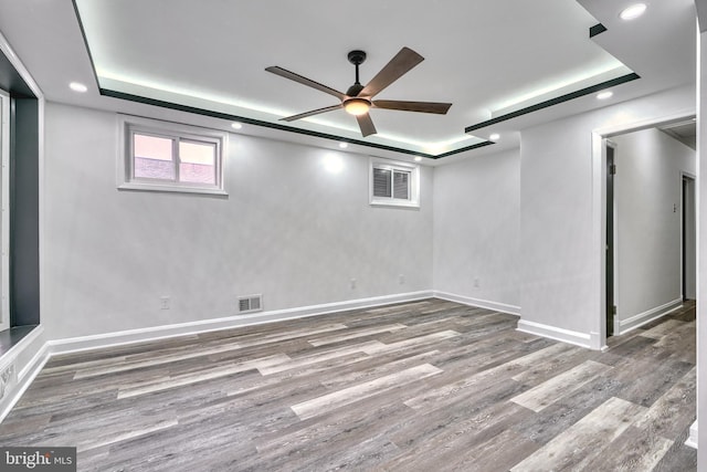 basement featuring wood-type flooring and ceiling fan