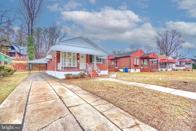 bungalow-style home featuring a front yard and covered porch