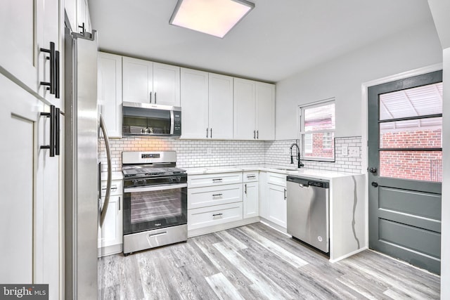 kitchen featuring appliances with stainless steel finishes, sink, and white cabinets