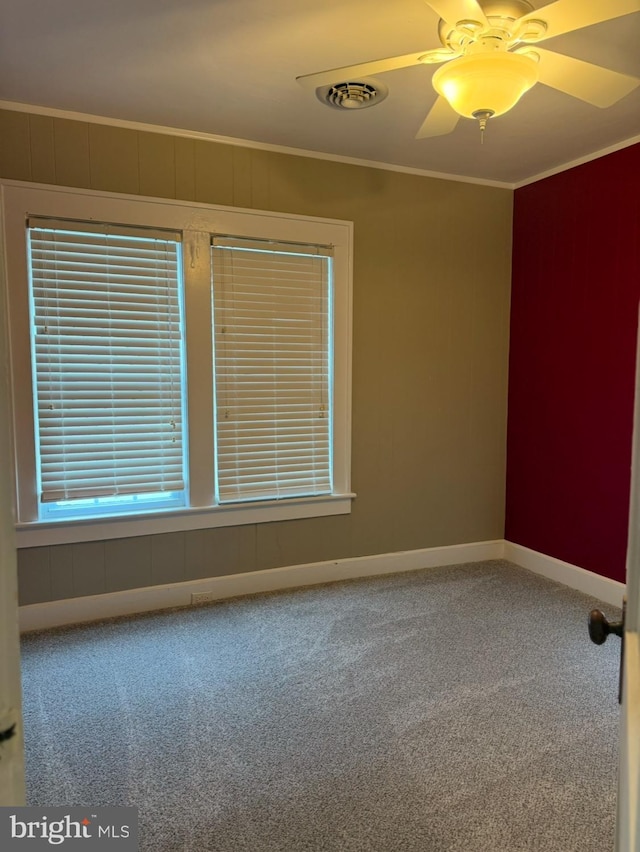 spare room with crown molding, carpet floors, and ceiling fan