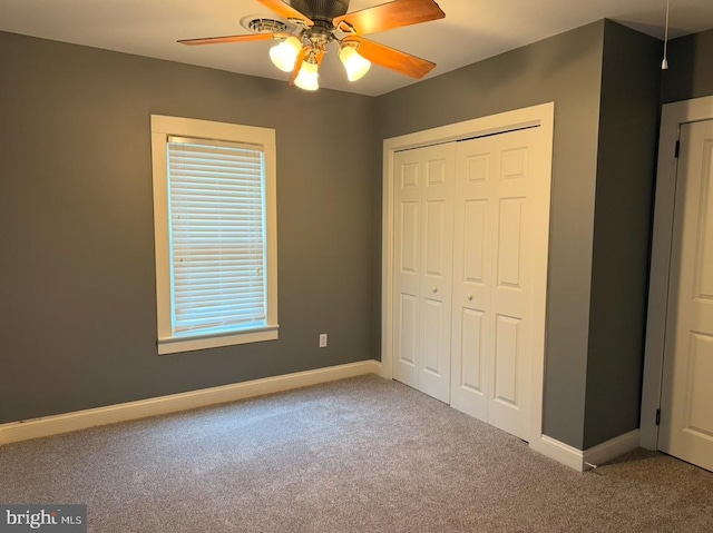 unfurnished bedroom with ceiling fan, a closet, and carpet