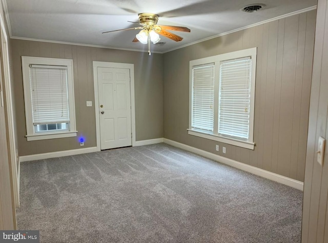 carpeted spare room with ornamental molding and ceiling fan