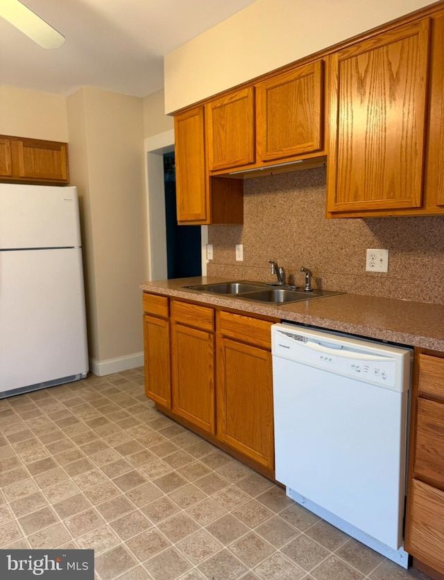 kitchen with white appliances, sink, and backsplash