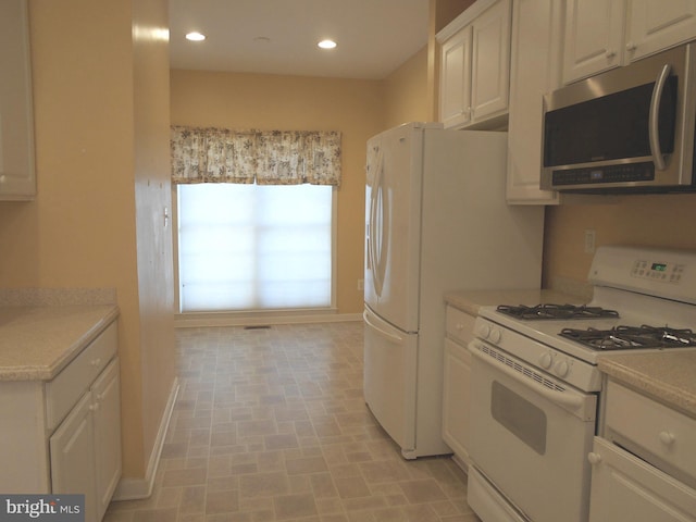 kitchen with white cabinetry and white range with gas stovetop