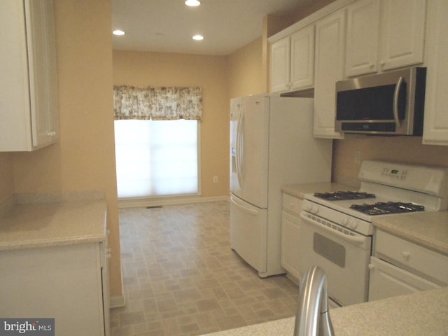 kitchen with white cabinetry and white appliances