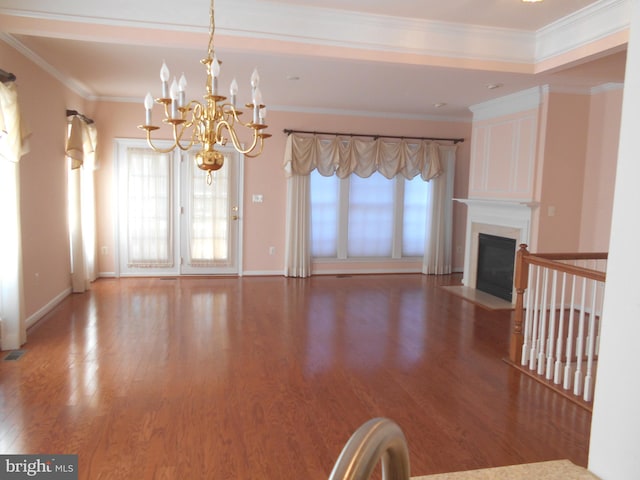 unfurnished living room with ornamental molding, hardwood / wood-style floors, and a chandelier