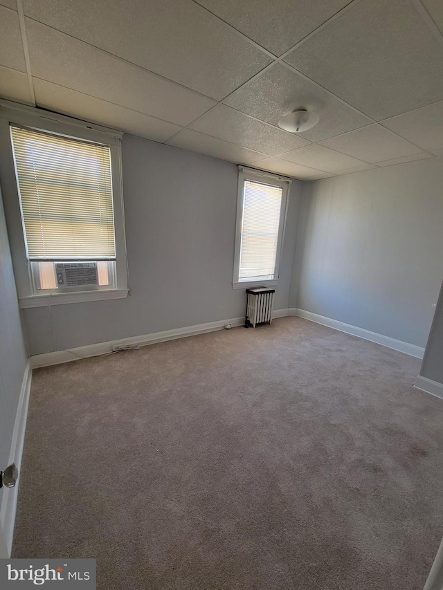 unfurnished room with carpet, a paneled ceiling, and cooling unit