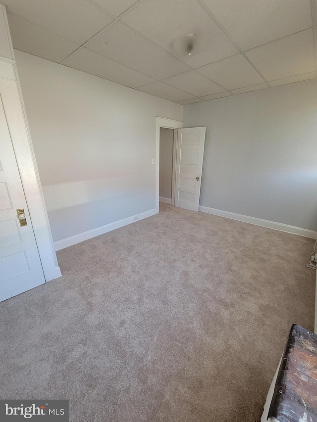 carpeted empty room featuring a paneled ceiling