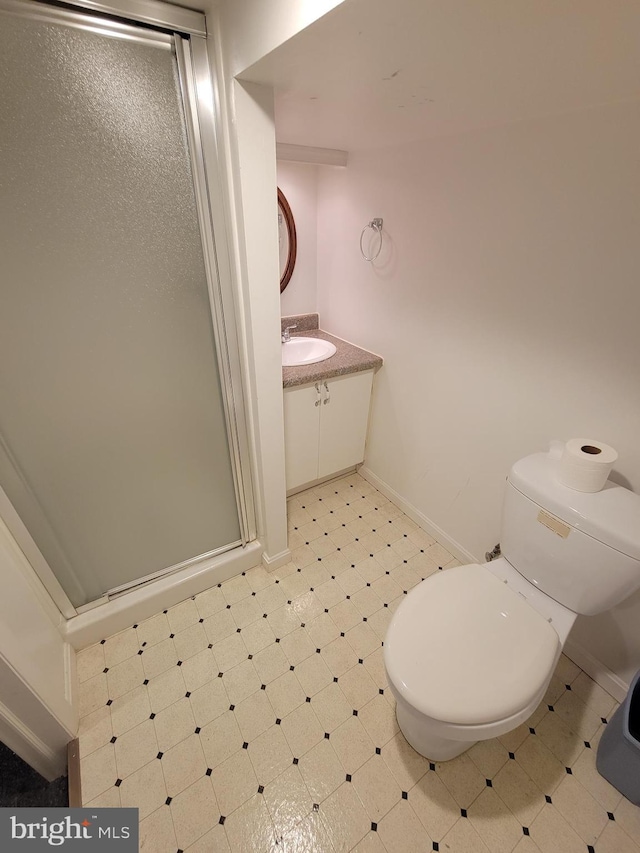 bathroom with a shower with door, vanity, and toilet