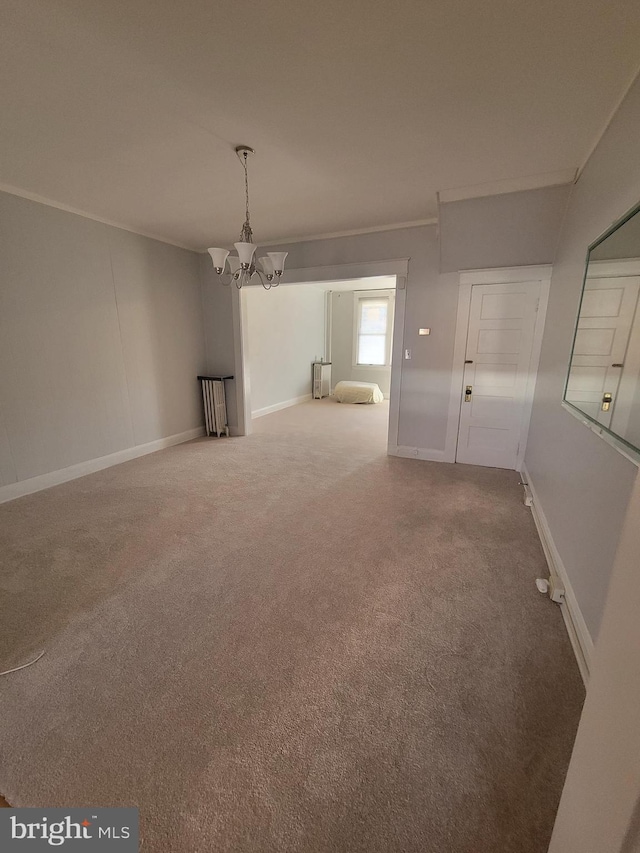 empty room featuring ornamental molding, carpet flooring, and an inviting chandelier