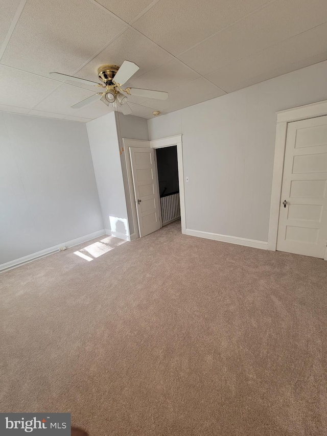 carpeted spare room with a paneled ceiling and ceiling fan