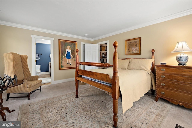 carpeted bedroom with crown molding and ensuite bath