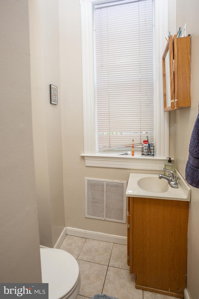 half bath featuring toilet, vanity, visible vents, tile patterned flooring, and baseboards