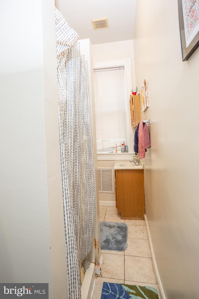 bathroom featuring a stall shower, baseboards, tile patterned floors, and visible vents