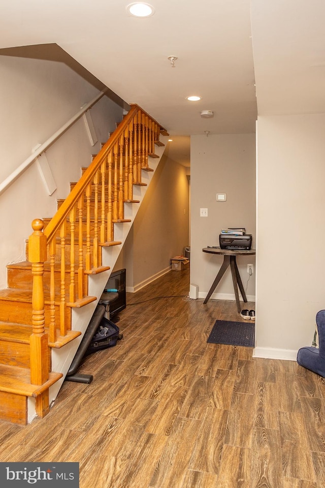 staircase with baseboards, recessed lighting, and wood finished floors