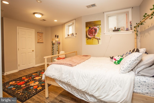 bedroom with visible vents, wood finished floors, baseboards, and recessed lighting