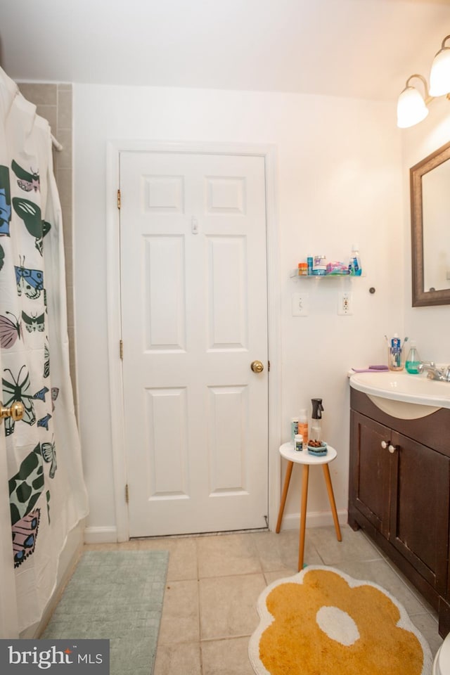 full bath featuring tile patterned floors, a shower with shower curtain, baseboards, and vanity
