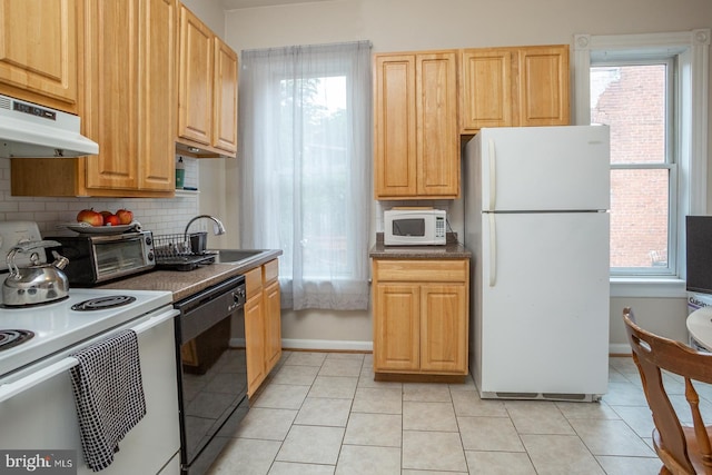 kitchen featuring white appliances, dark countertops, baseboards, backsplash, and under cabinet range hood