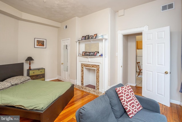 bedroom featuring visible vents, wood finished floors, and baseboards