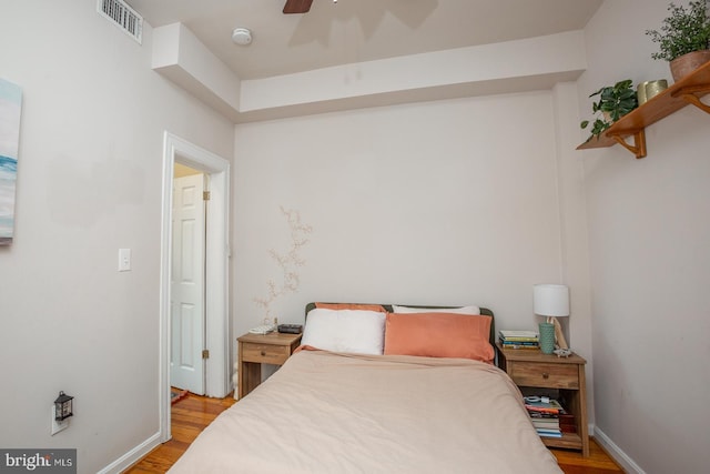 bedroom featuring light wood-type flooring, visible vents, and baseboards