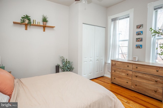 bedroom featuring a ceiling fan, a closet, and light wood-style flooring
