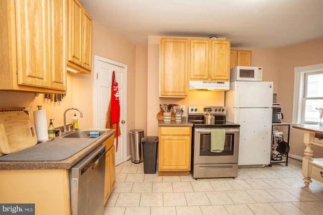 kitchen with a sink, under cabinet range hood, light brown cabinetry, light tile patterned floors, and appliances with stainless steel finishes