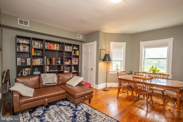 living area featuring baseboards, visible vents, and wood-type flooring