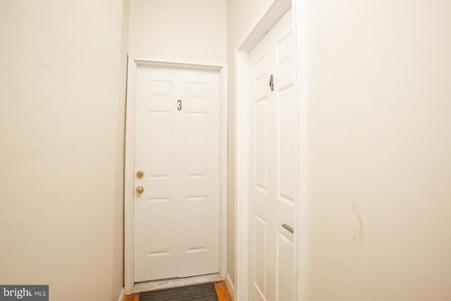 doorway to outside featuring baseboards and wood finished floors