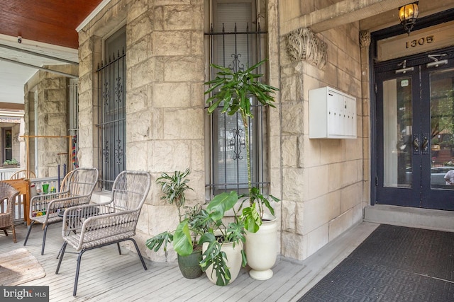 doorway to property featuring stone siding and french doors