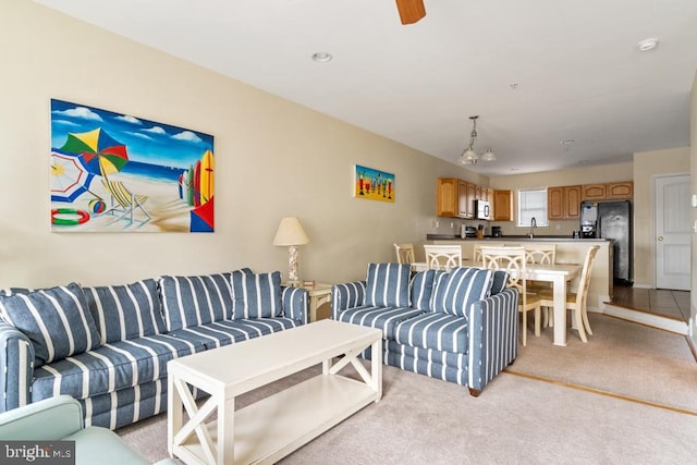 living room featuring sink and light carpet