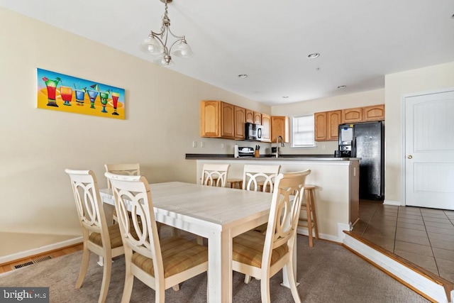 dining area featuring an inviting chandelier and sink