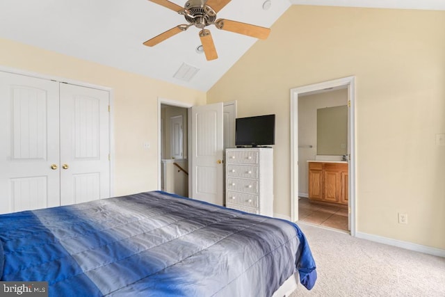 bedroom featuring ensuite bathroom, high vaulted ceiling, light carpet, and ceiling fan